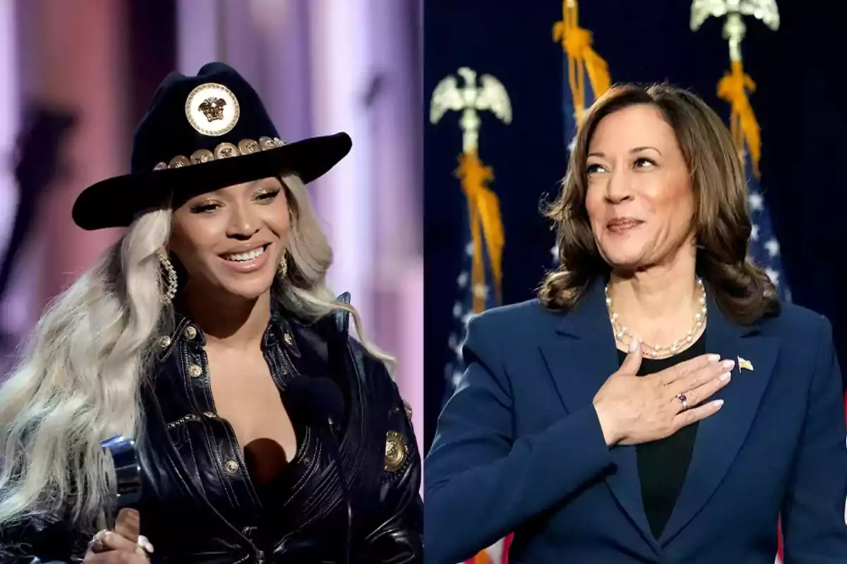 Dos mujeres sonrientes en un evento, una con sombrero y micrófono, la otra con traje formal y fondo de banderas.