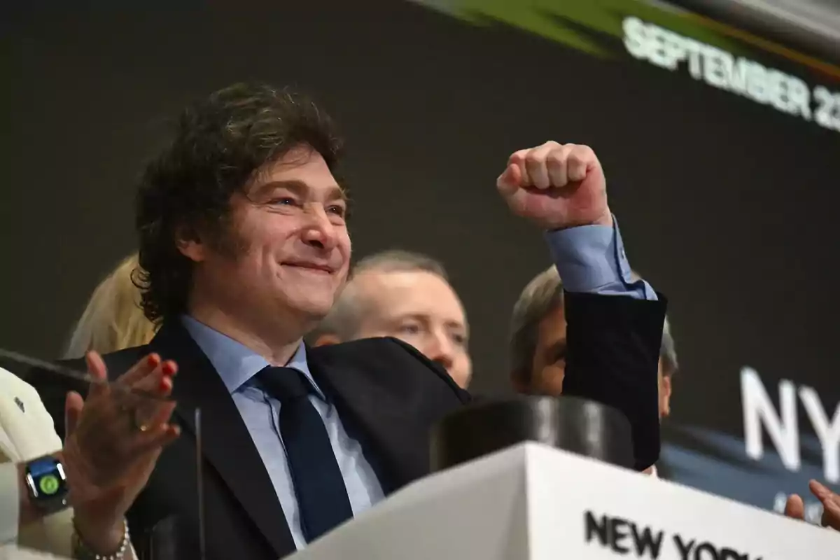 A smiling man with his fist raised at an event in New York.