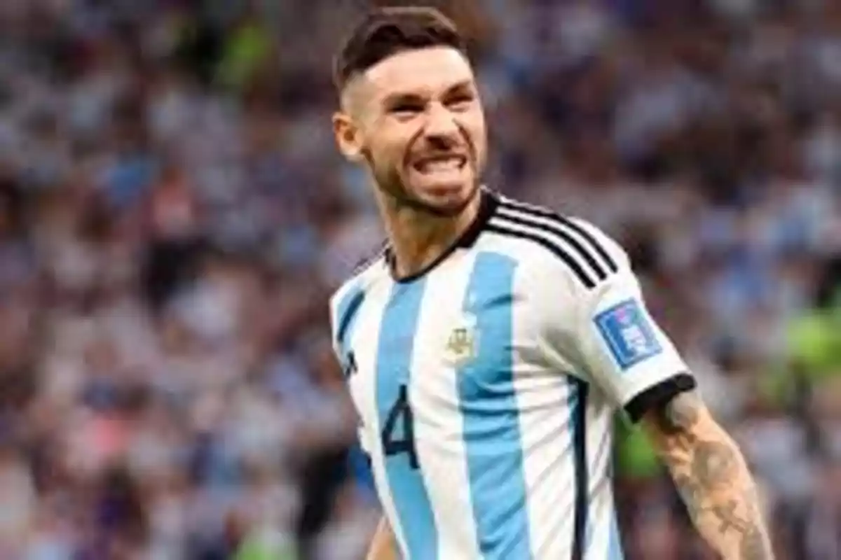 Jugador de fútbol con la camiseta de Argentina celebrando en el campo.