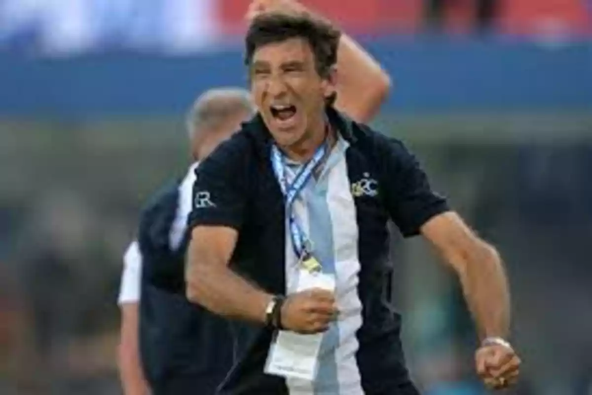 Un hombre celebrando con entusiasmo en un evento deportivo, vistiendo una camiseta con los colores celeste y blanco.