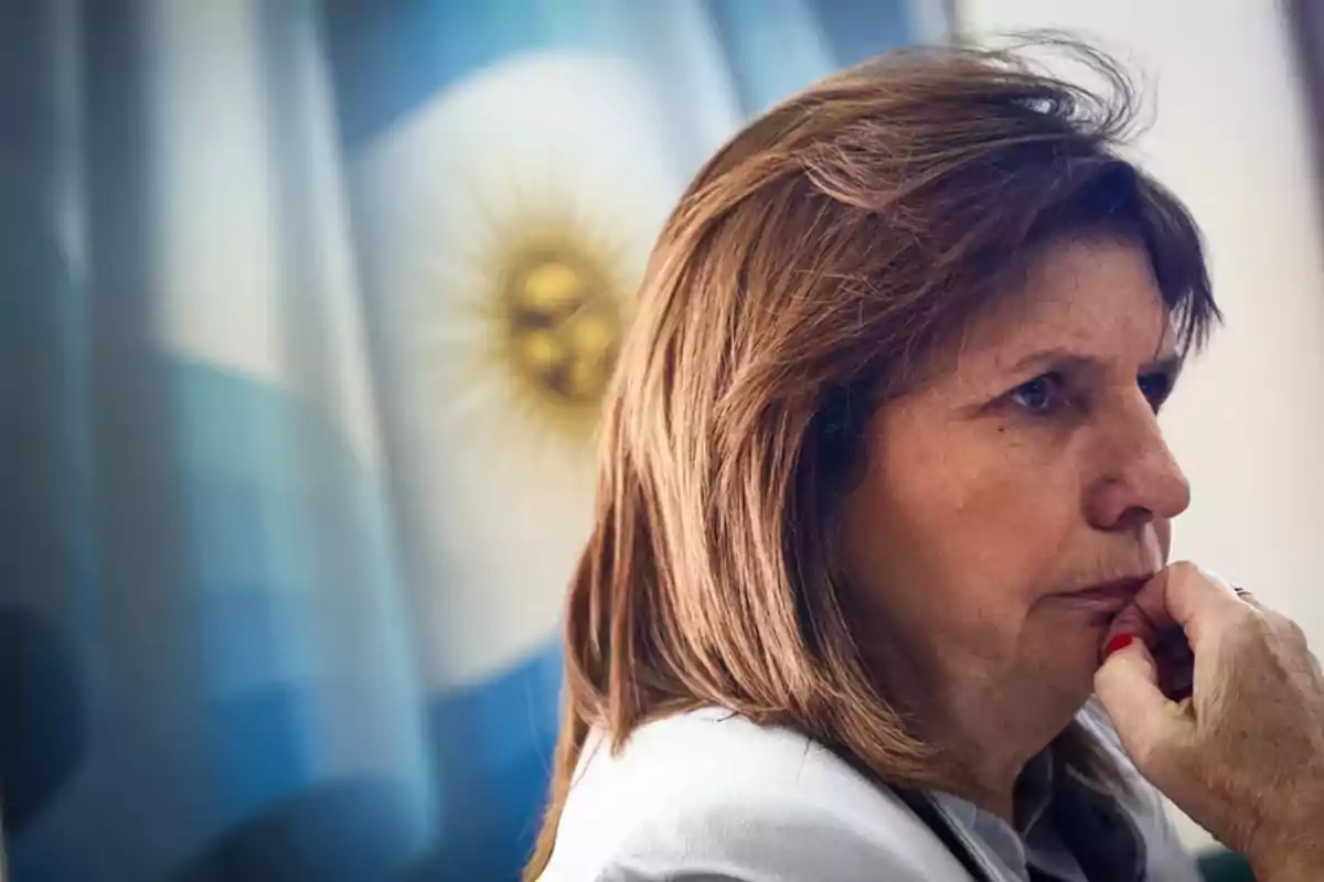 Mujer pensativa con la bandera de Argentina de fondo.