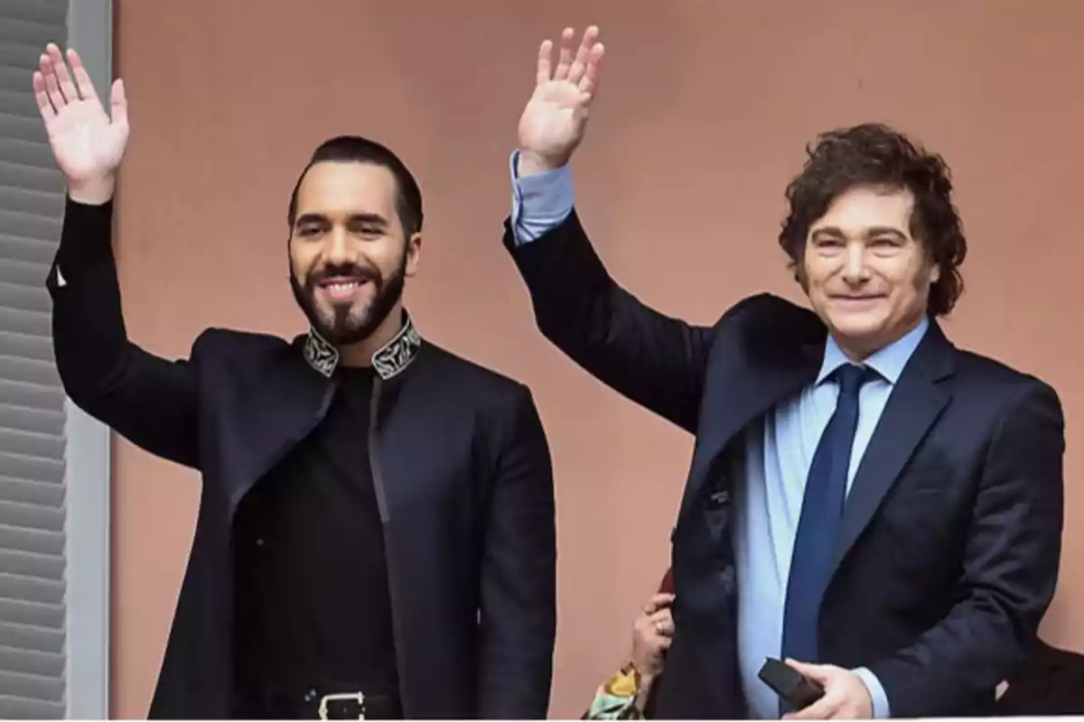 Dos hombres sonrientes levantando la mano en señal de saludo.