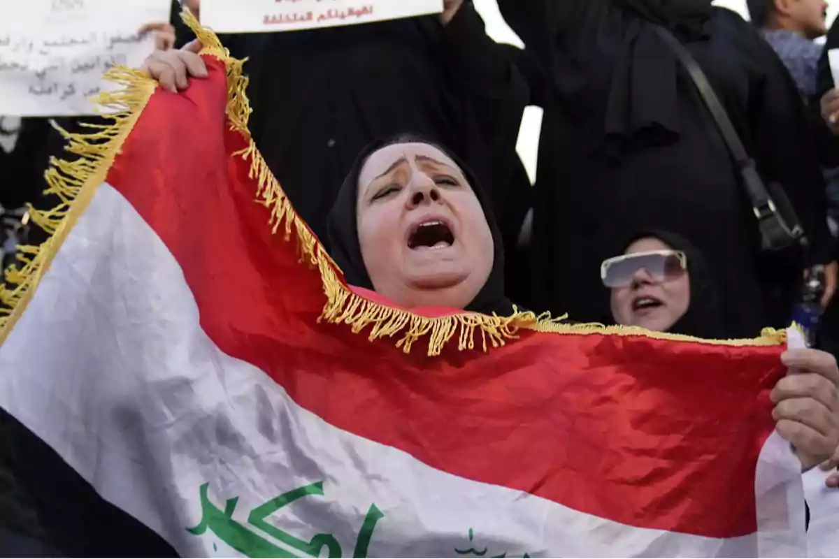 Mujer sosteniendo una bandera en una manifestación.