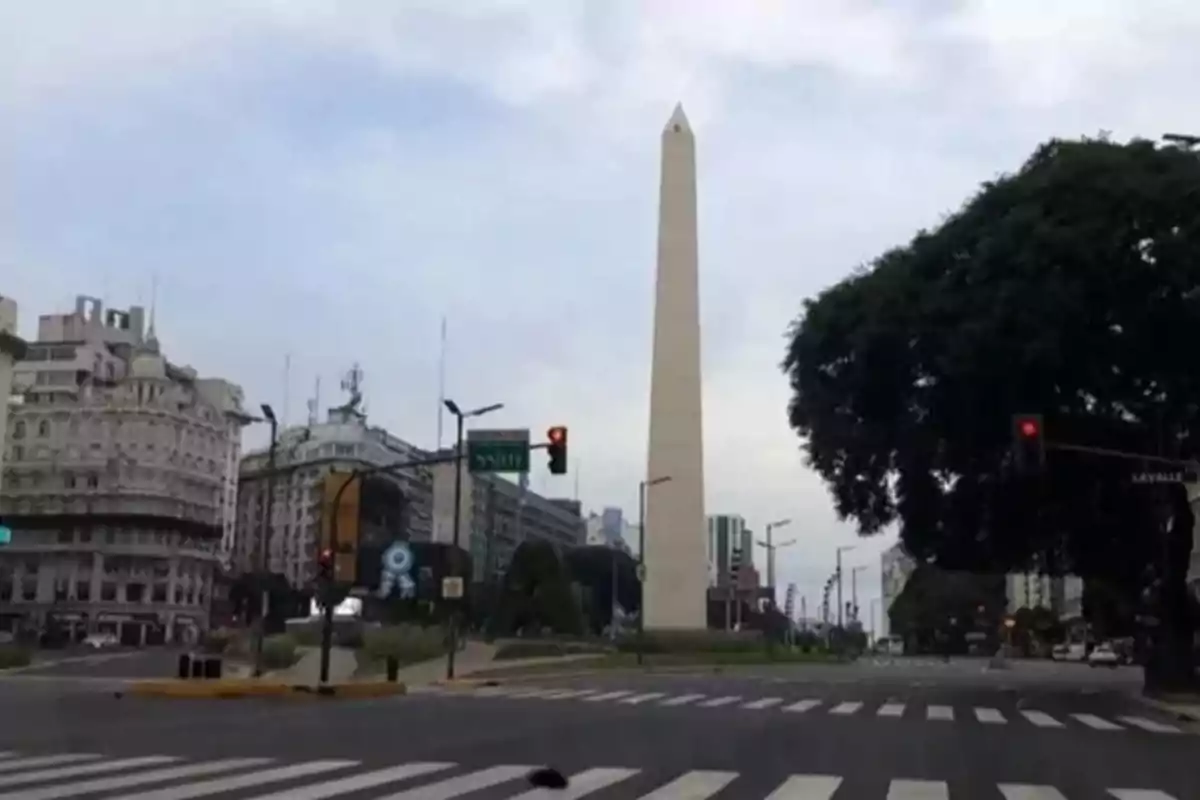 Vista del Obelisco de Buenos Aires en una intersección con edificios y árboles alrededor.