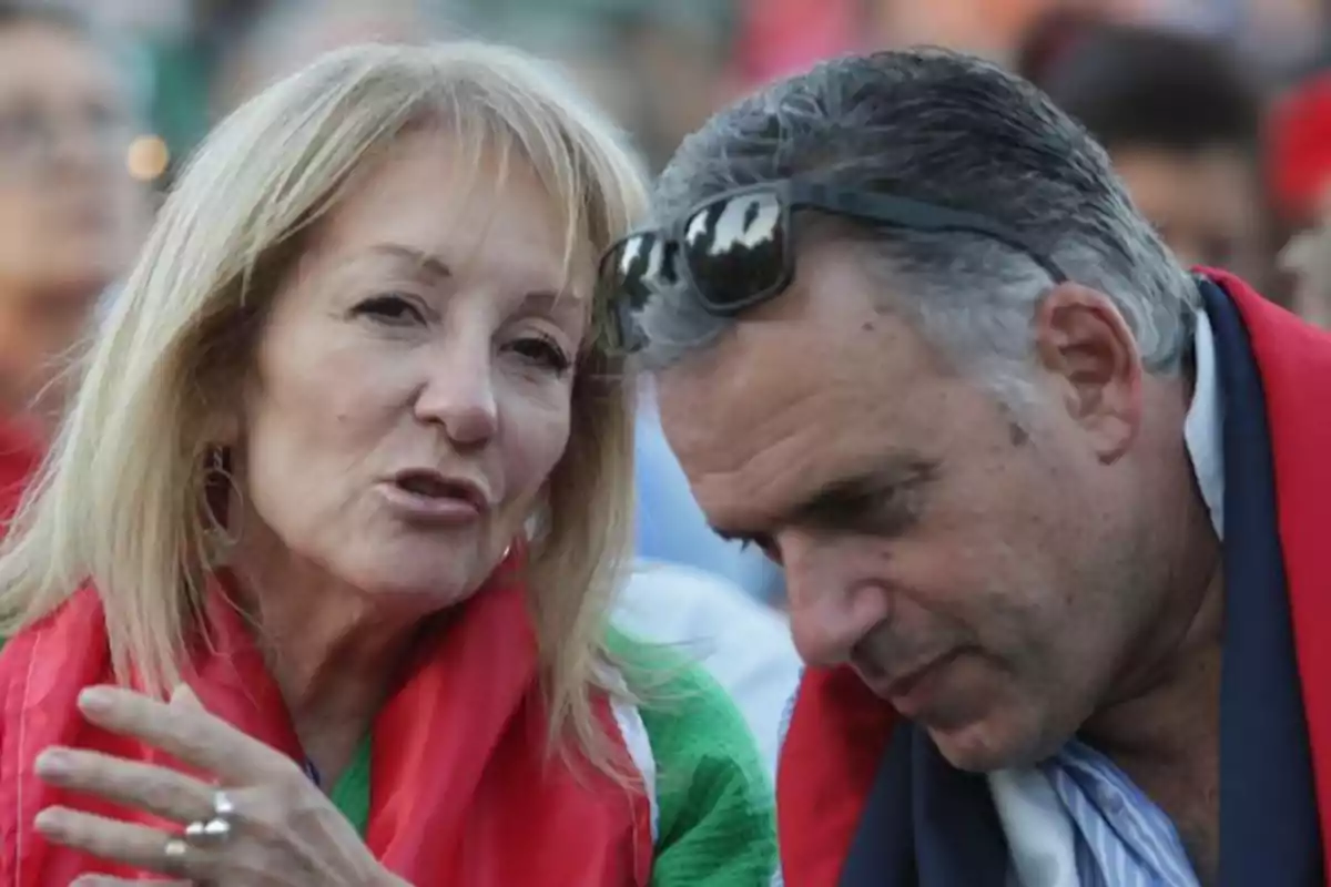 Dos personas conversando en un evento al aire libre.