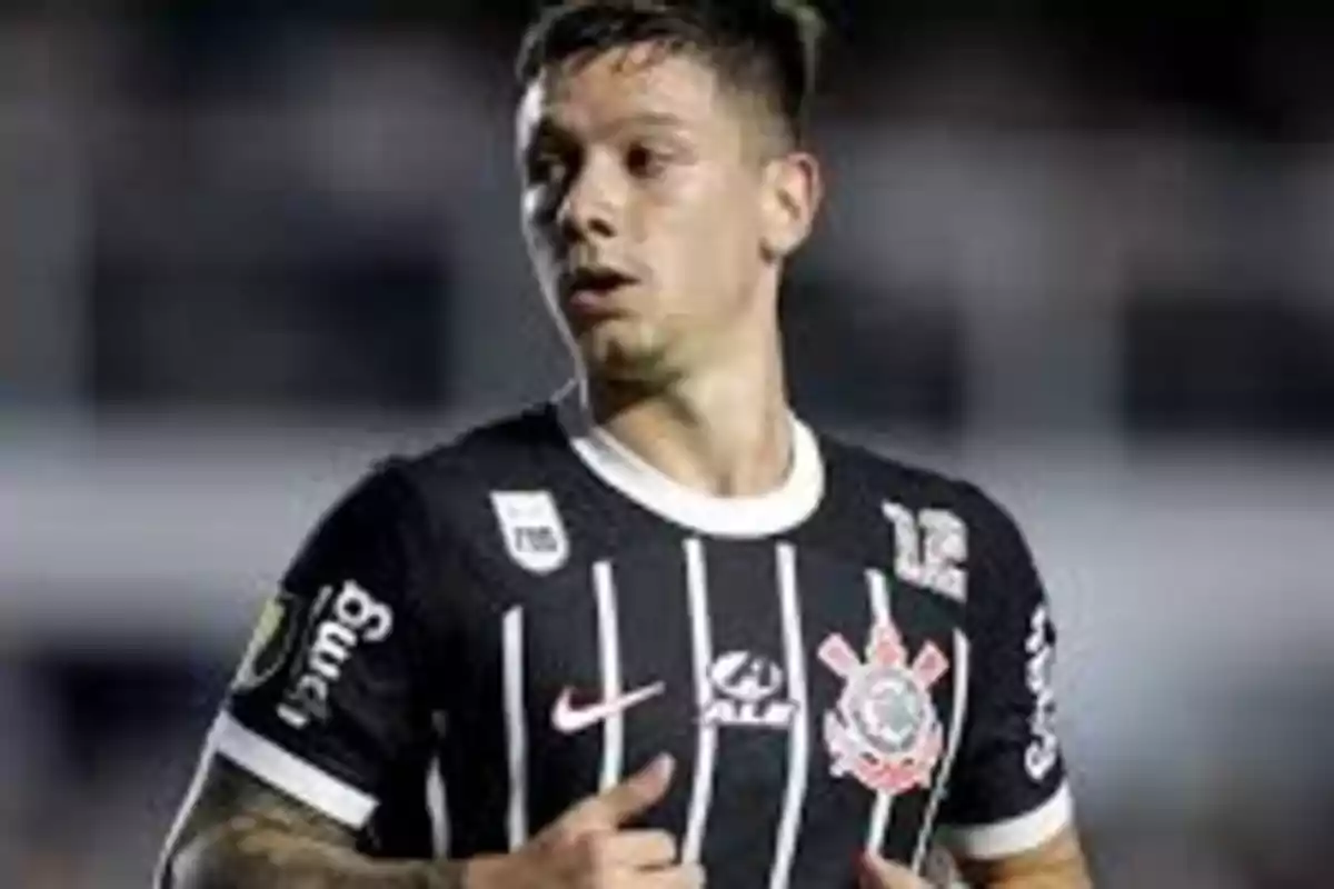 Jugador de fútbol con camiseta negra de rayas blancas en el campo.