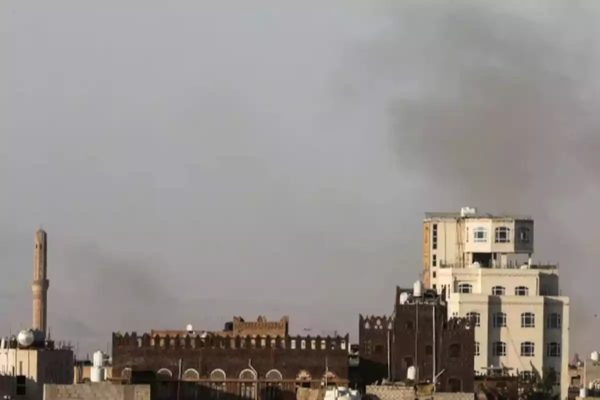 Edificios tradicionales y modernos con humo en el cielo en una ciudad.