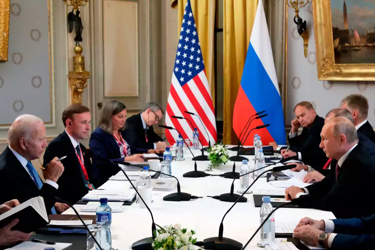 Diplomatic meeting between delegations from two countries with United States and Russian flags on the table.