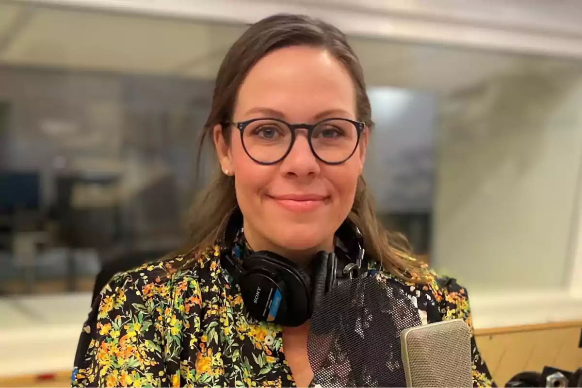 Mujer con gafas y auriculares en un estudio de grabación.