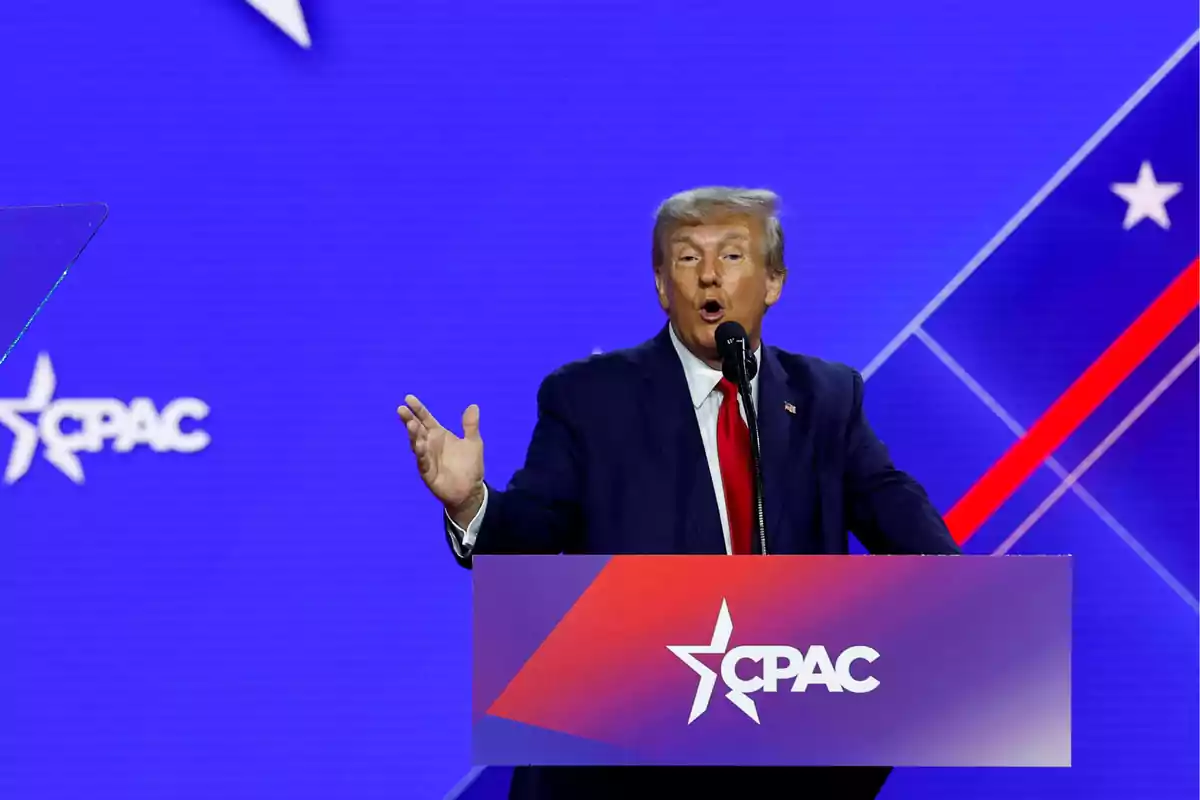 Una persona hablando en un podio con el logo de CPAC sobre un fondo azul.