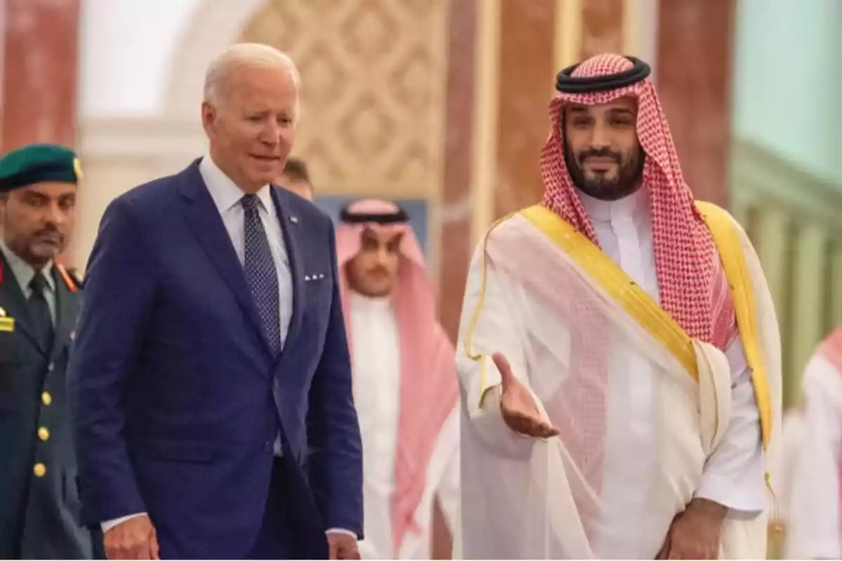 Dos hombres caminando juntos en un evento formal con trajes tradicionales y de negocios.