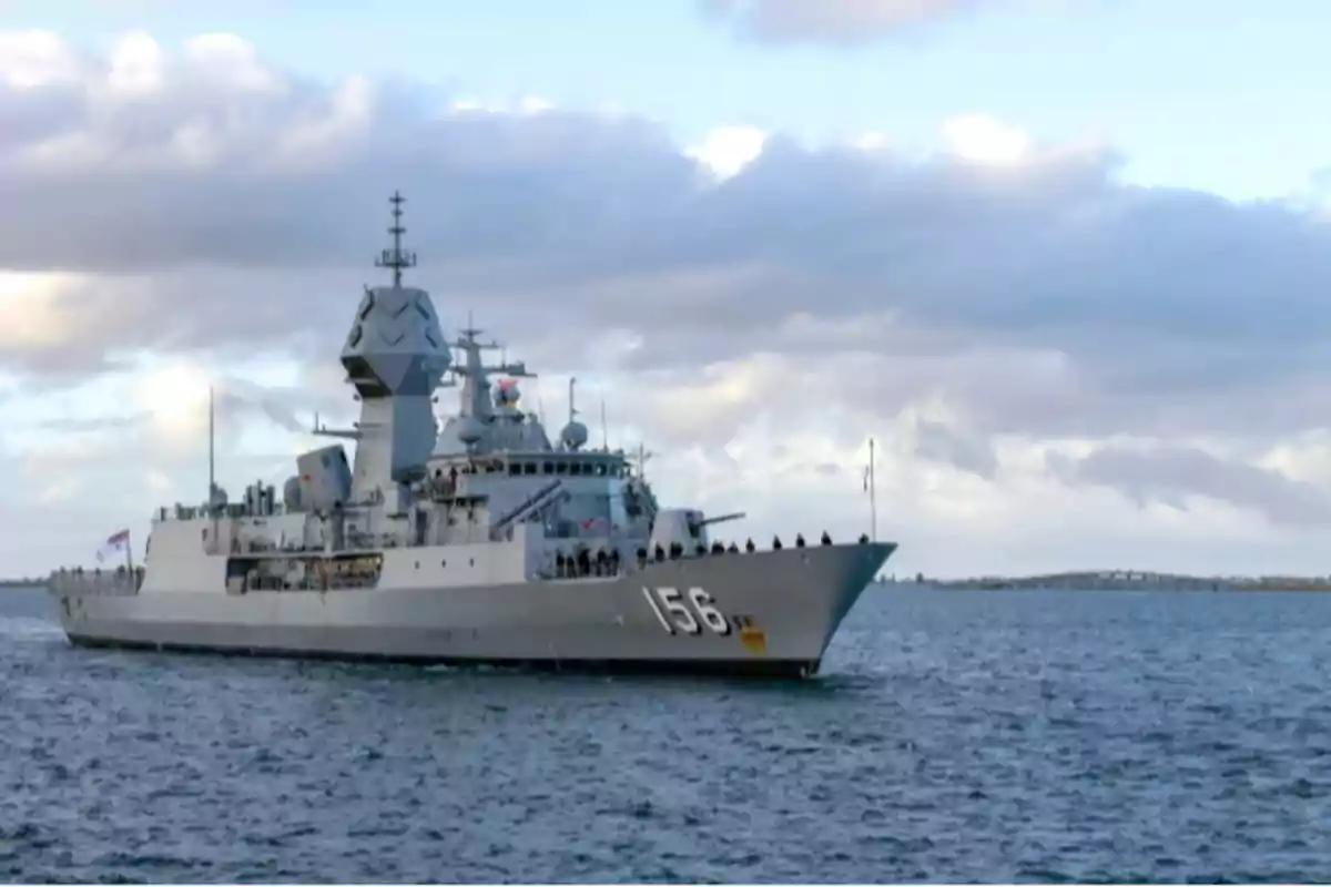 Un buque de guerra navegando en el mar bajo un cielo nublado.