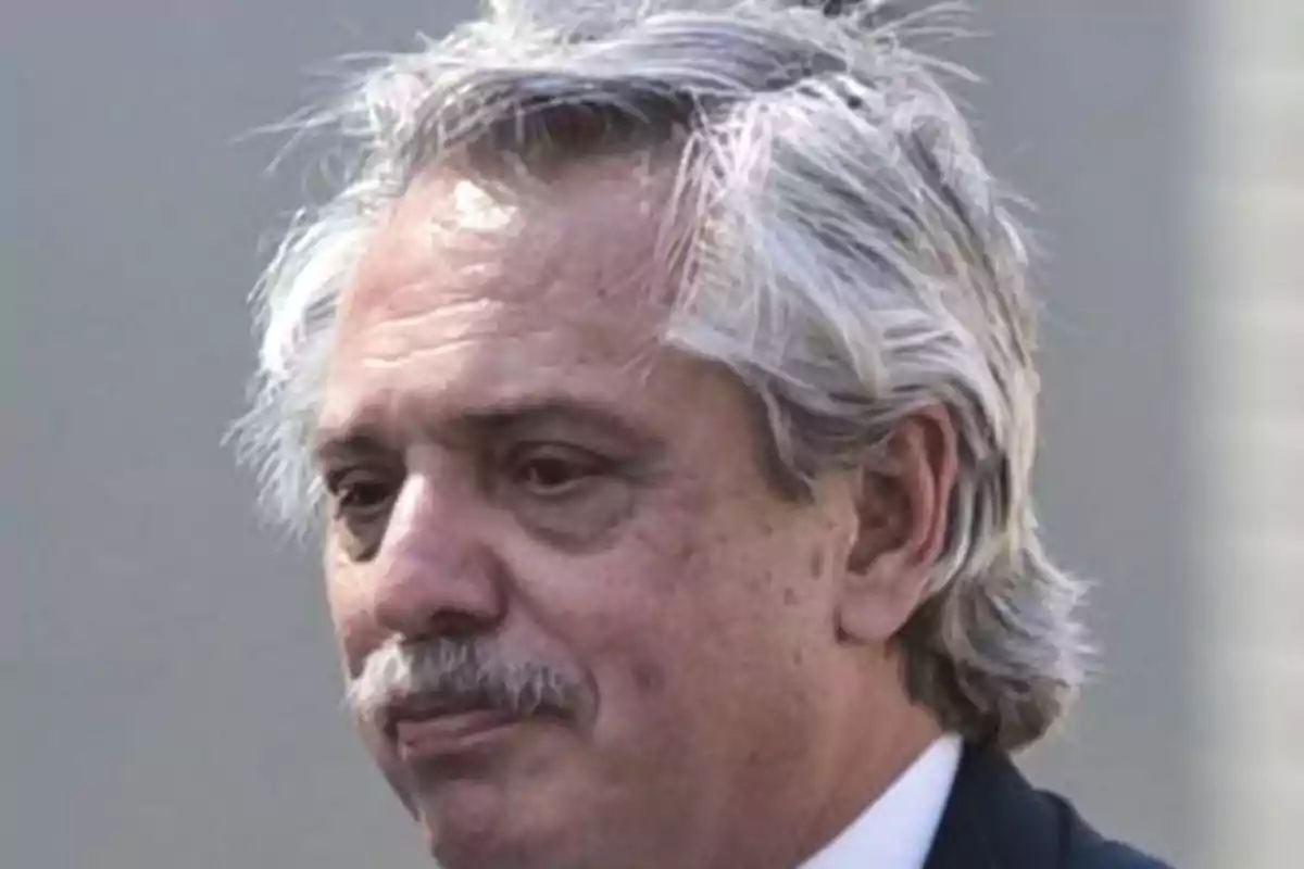 Un hombre de cabello canoso y bigote con expresión seria.