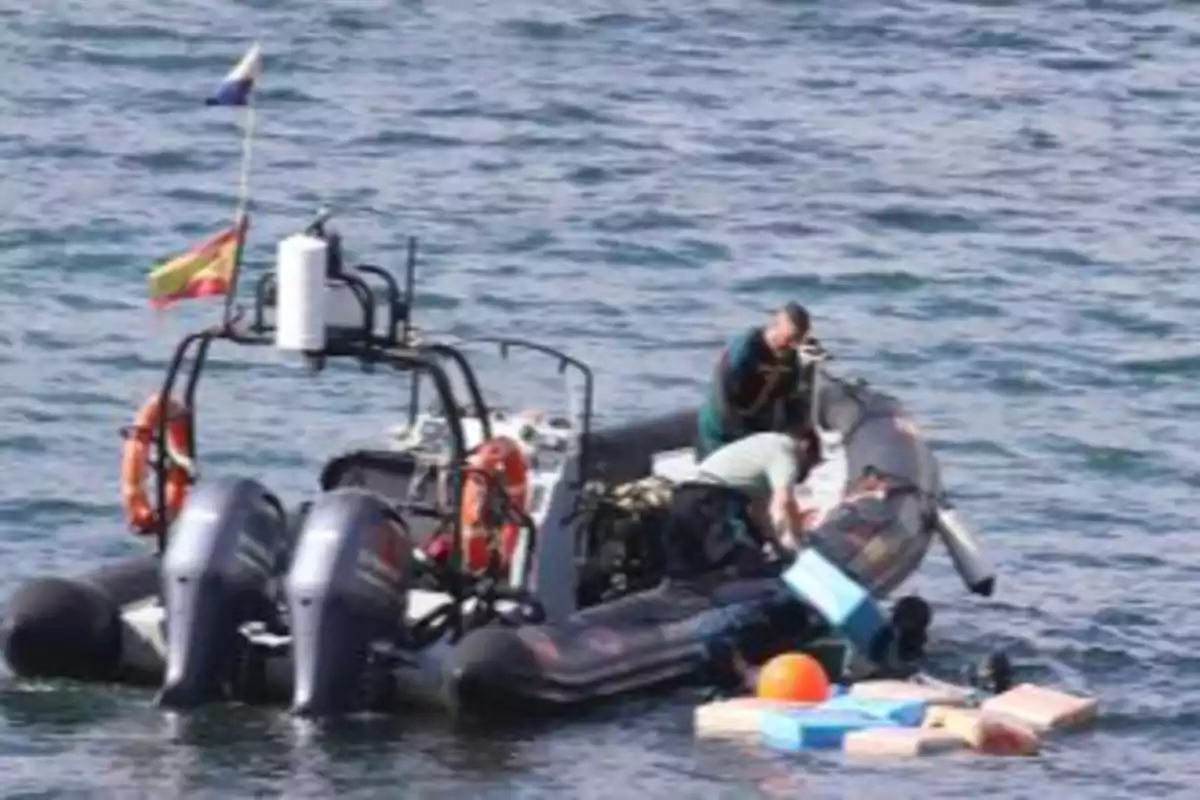 Una lancha en el agua con dos personas a bordo y varias cajas flotando cerca.