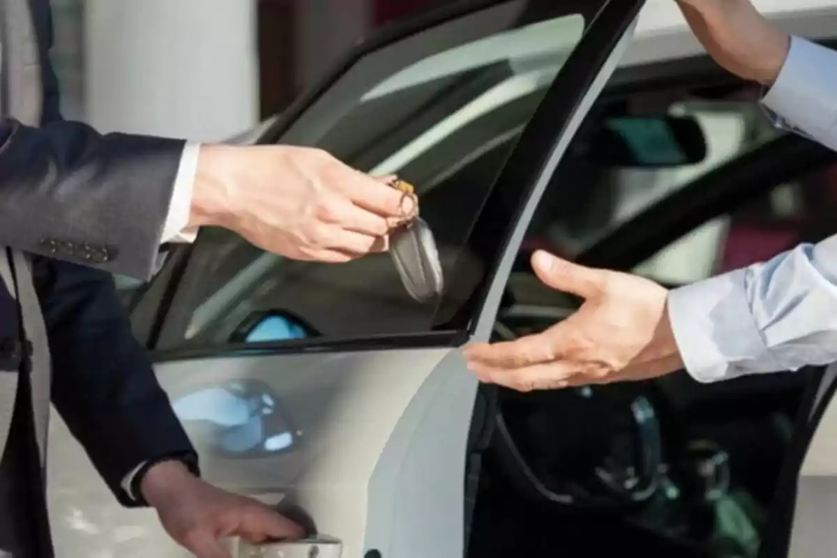 Una persona entregando las llaves de un coche a otra persona