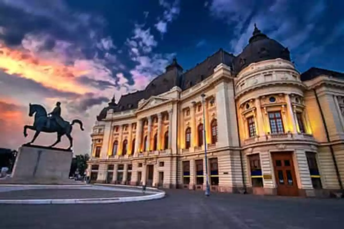 Edificio histórico con arquitectura clásica y estatua ecuestre al atardecer.