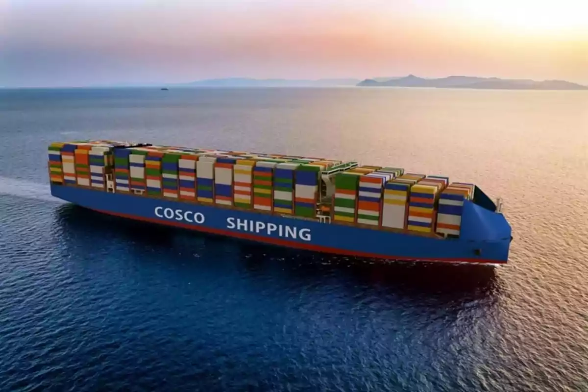 Un gran barco portacontenedores de COSCO navegando en el océano al atardecer.