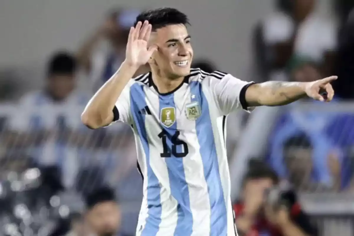 Jugador de fútbol con la camiseta de Argentina celebrando en el campo.