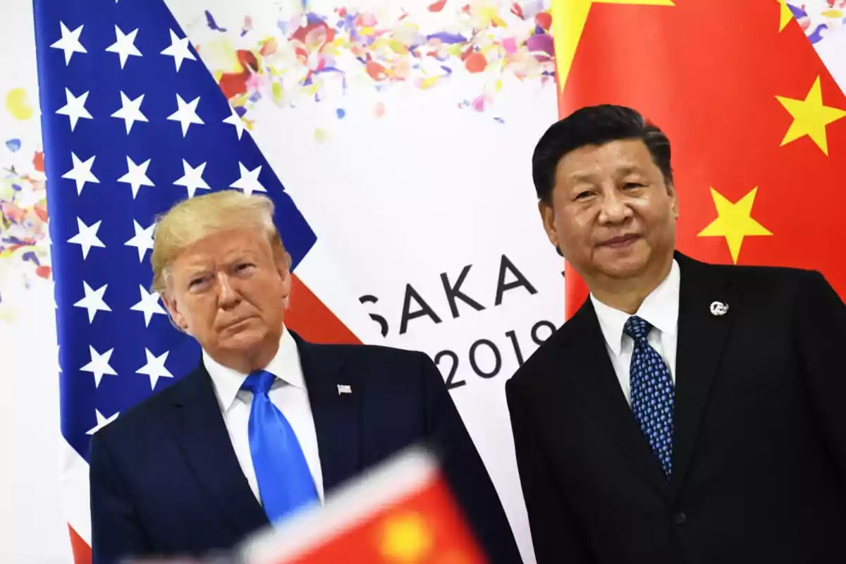 Dos personas posan frente a las banderas de Estados Unidos y China en un evento en Osaka 2019.