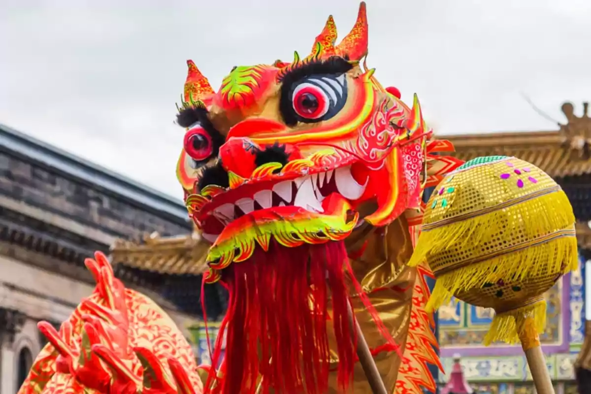 Un colorido dragón chino de papel maché con detalles rojos y amarillos en un desfile del año nuevo chino 2025.