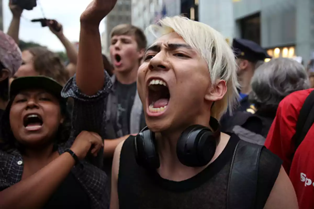 Personas participando en una protesta, mostrando expresiones de entusiasmo y determinación.