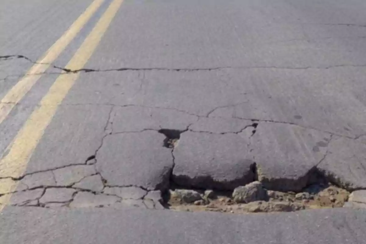 Carretera con grietas y baches en el pavimento.