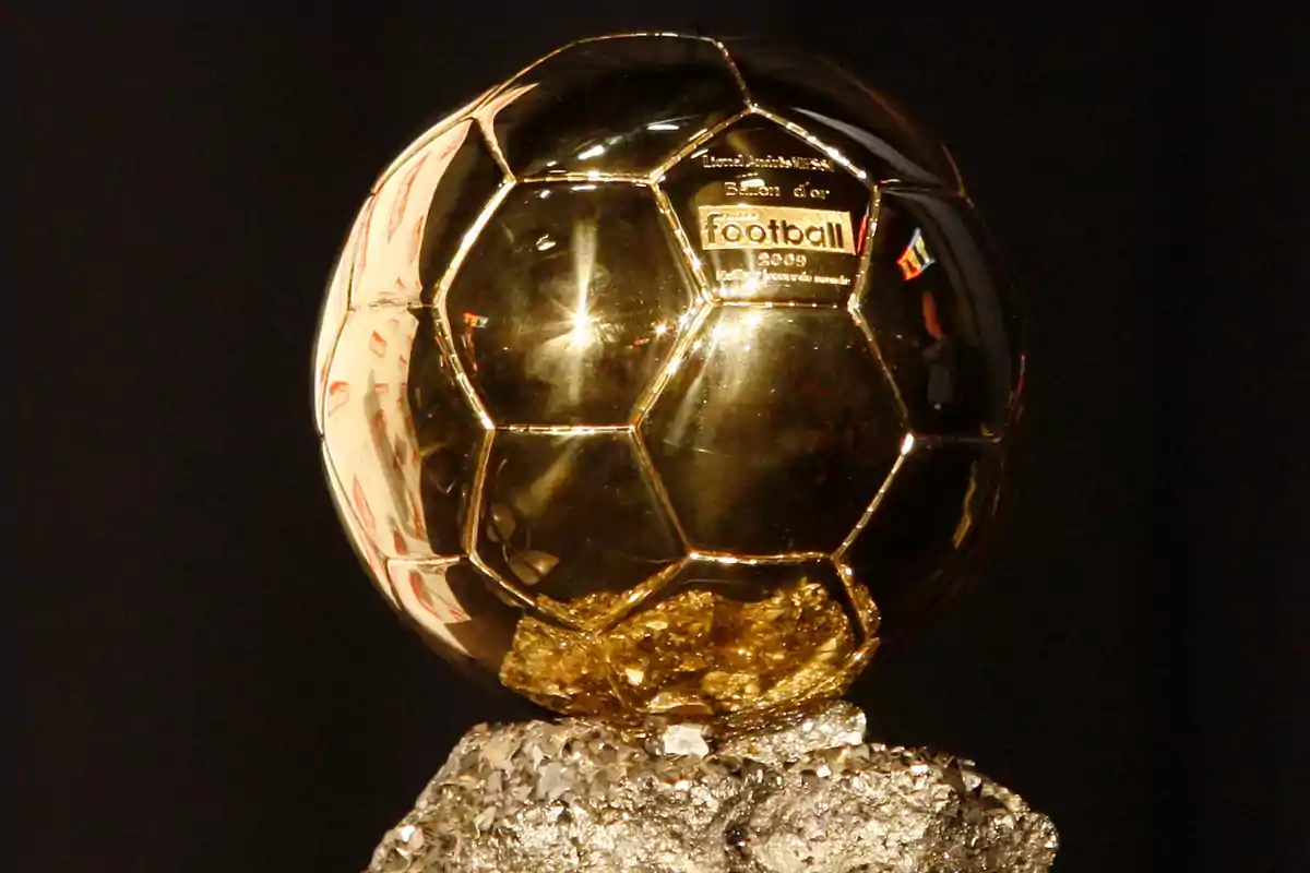 Trofeo del Balón de Oro sobre un pedestal de piedra.