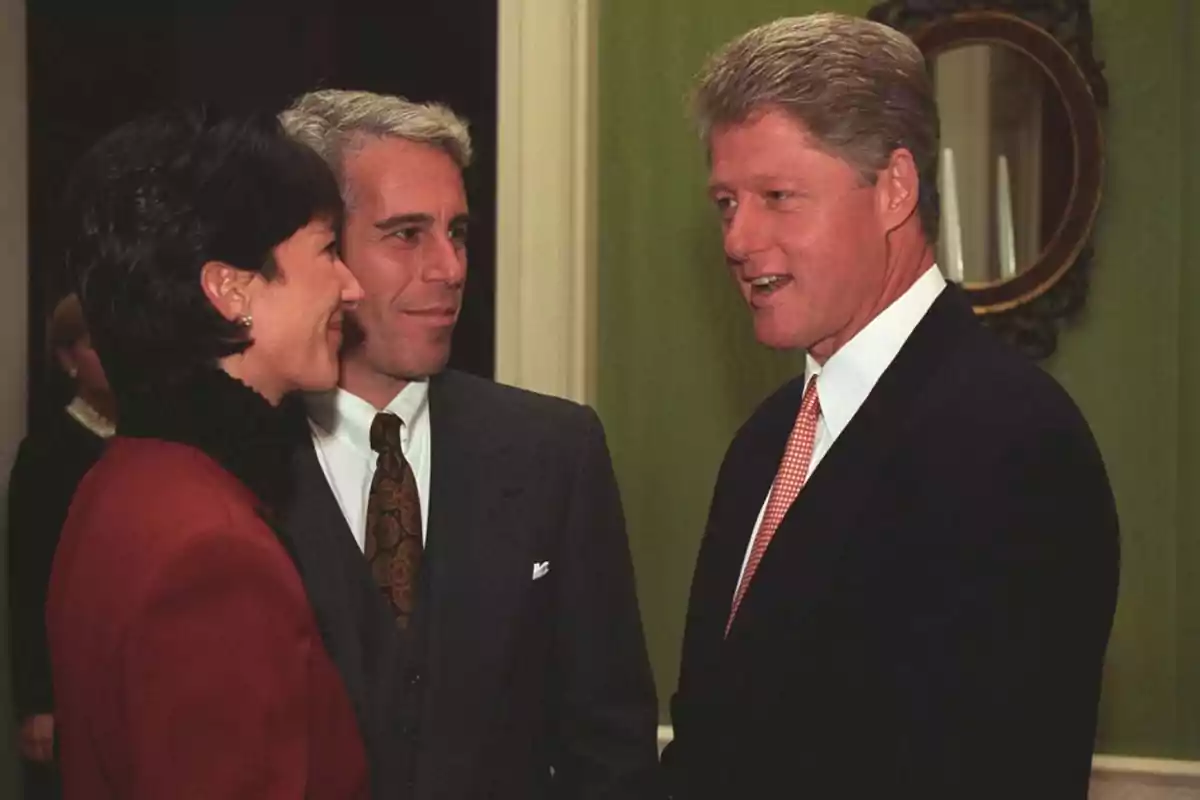 Tres personas conversando en un ambiente formal.