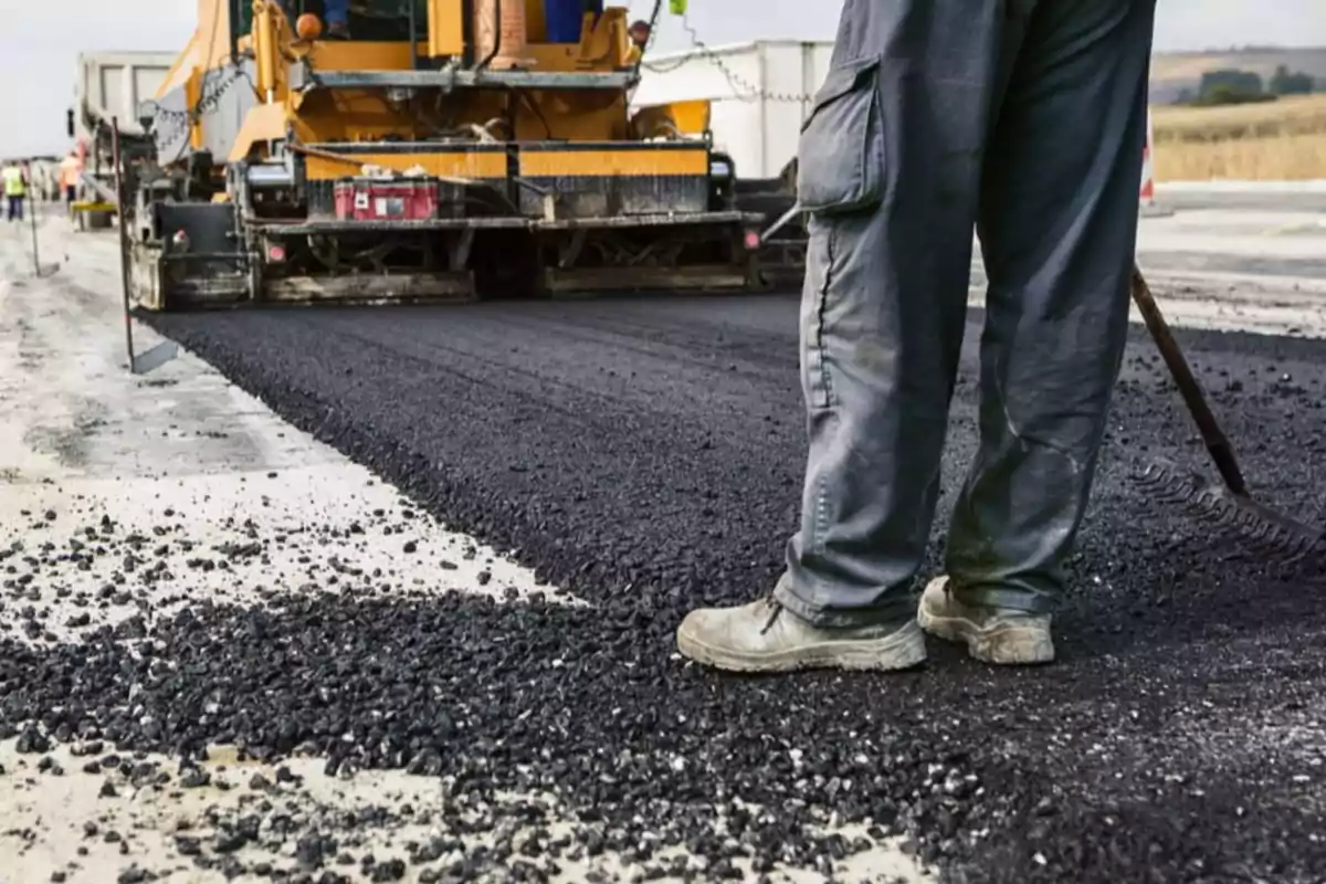 Trabajadores pavimentando una carretera con asfalto.