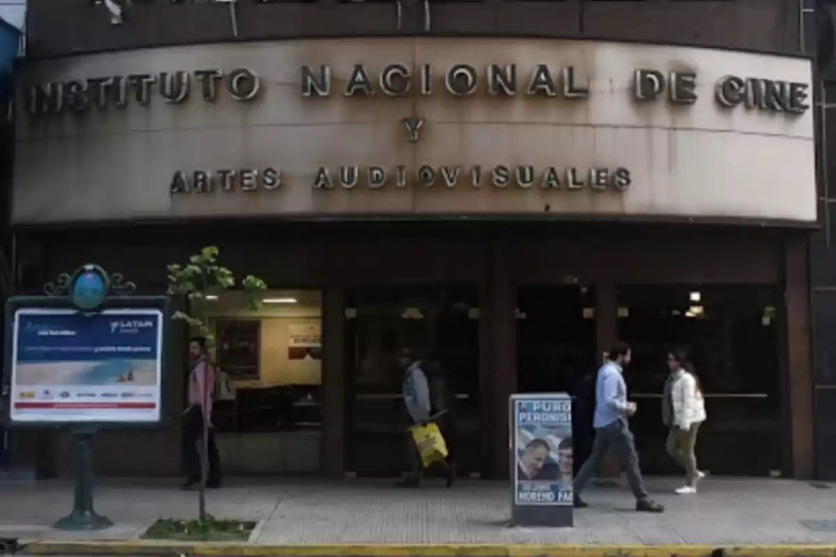 Fachada del Instituto Nacional de Cine y Artes Audiovisuales con personas caminando frente a la entrada.