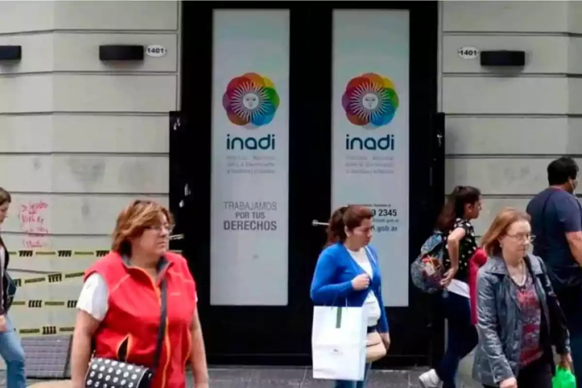 Personas caminando frente a la entrada del INADI (Instituto Nacional contra la Discriminación, la Xenofobia y el Racismo) en Argentina.