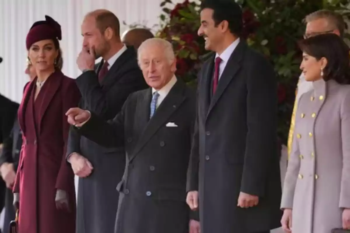 Un grupo de personas elegantemente vestidas conversando en un evento formal.