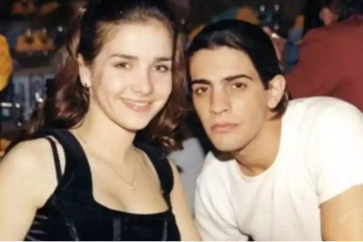 Una pareja joven posando juntos y sonriendo en un ambiente interior.