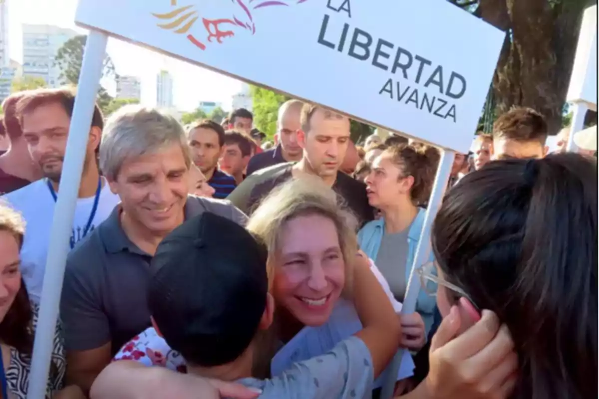 A group of people gathers outdoors holding a sign that says "Freedom Advances."