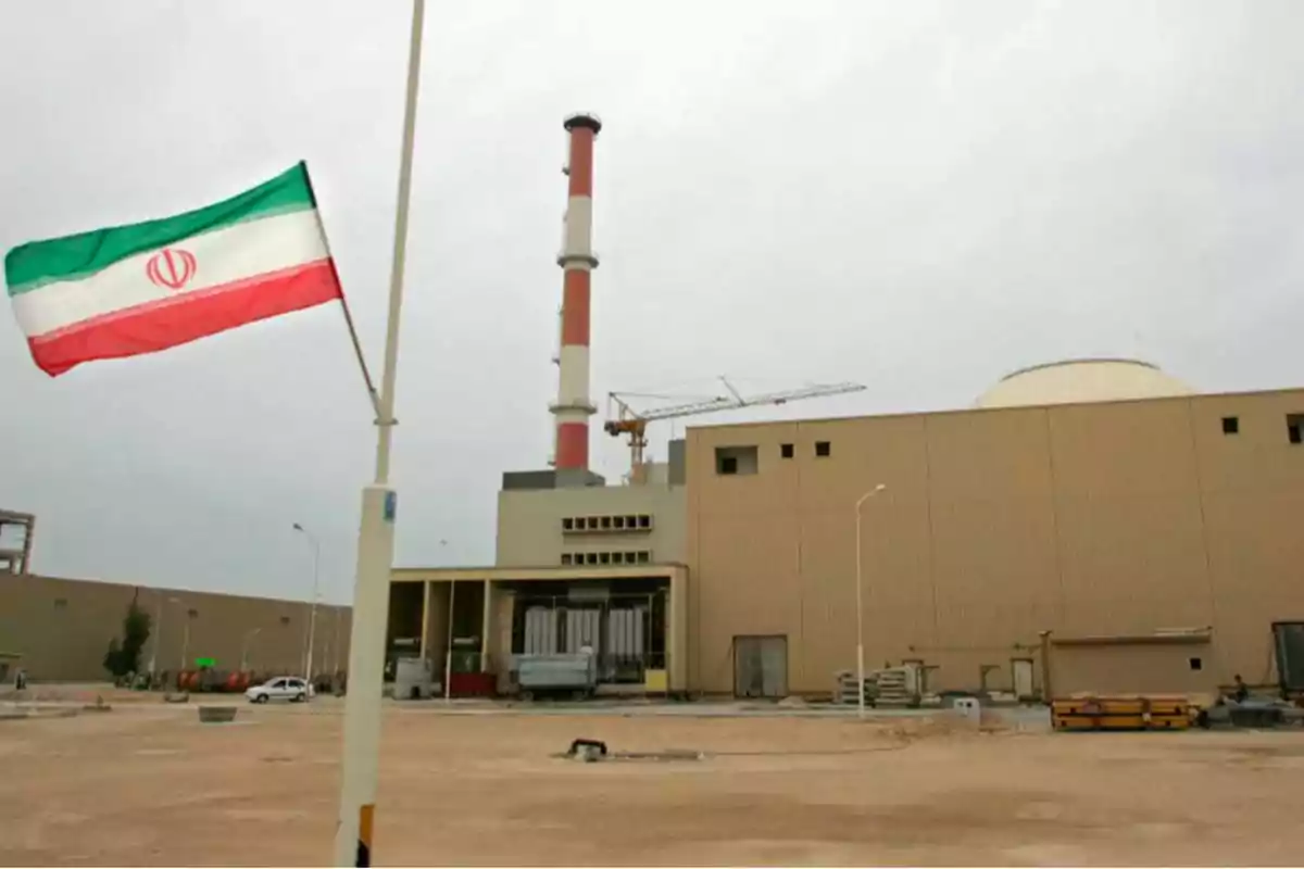 Una planta nuclear con una bandera de Irán ondeando en primer plano.