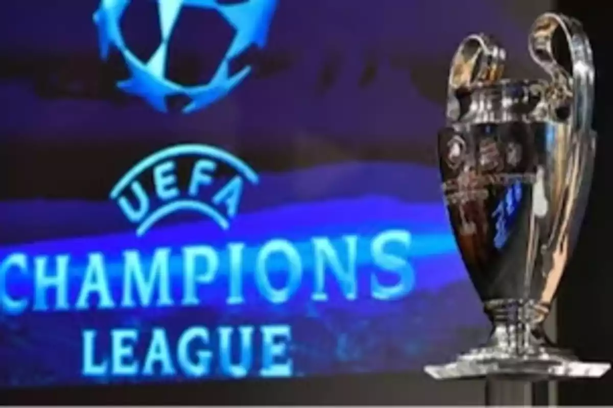 Trofeo de la UEFA Champions League frente a un fondo con el logo del torneo.