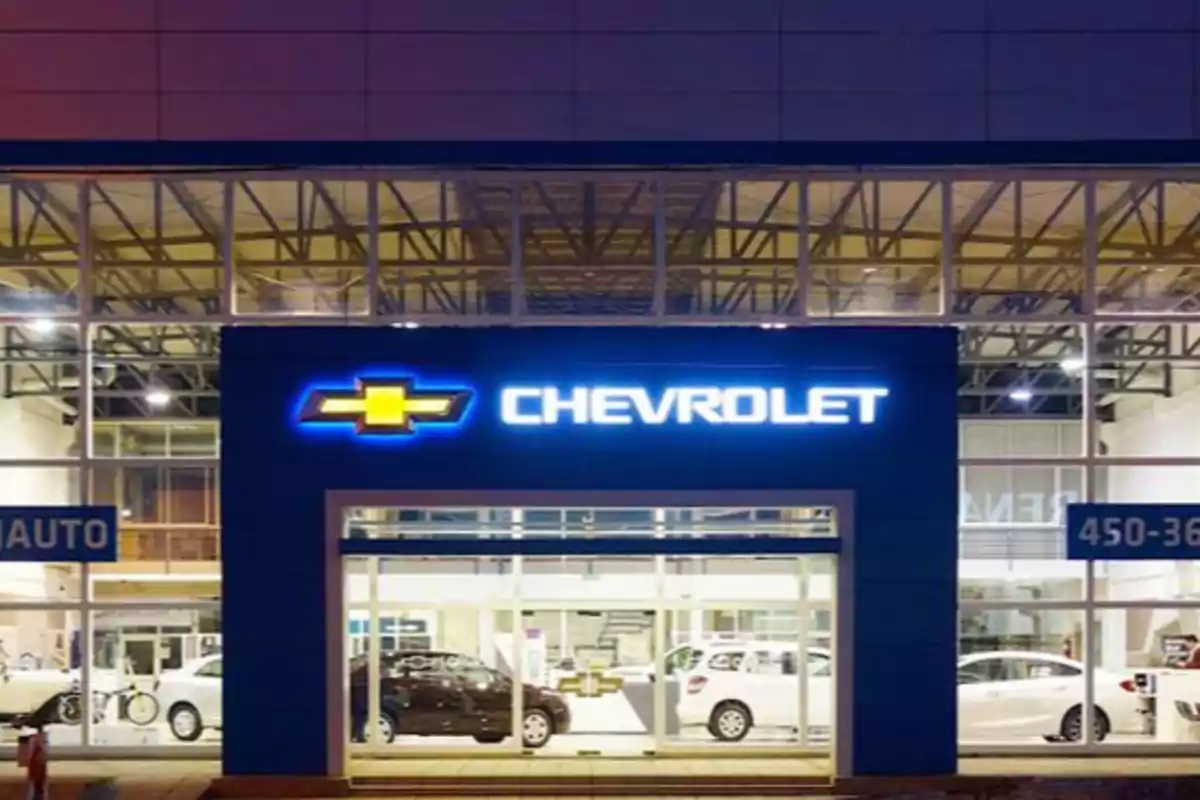 Fachada de un concesionario de automóviles Chevrolet iluminado por la noche.