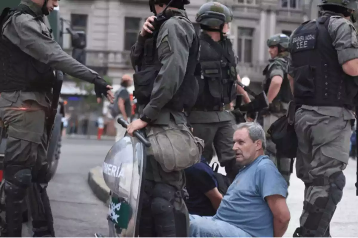 Un grupo de policías detiene a dos hombres en una calle de la ciudad.