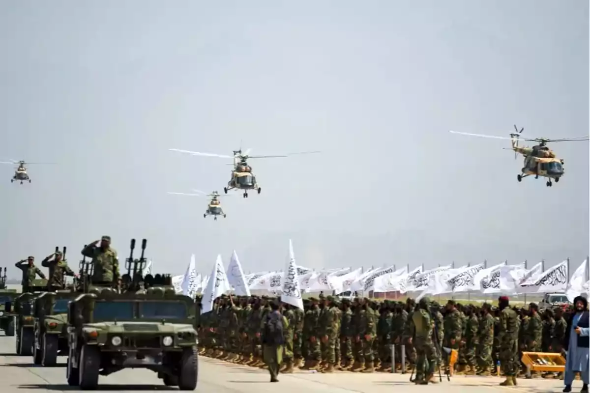 Desfile militar con soldados en formación, vehículos blindados y helicópteros sobrevolando.