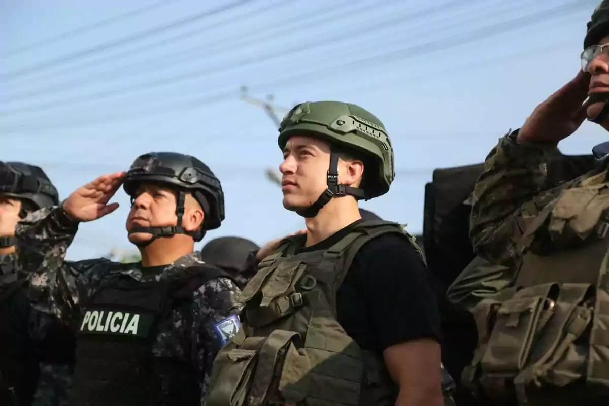 Un grupo de personas con uniformes militares y cascos realizando un saludo militar.