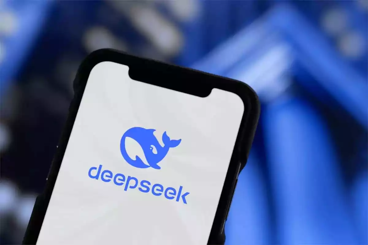 Teléfono móvil mostrando el logotipo de Deepseek en la pantalla con un fondo azul desenfocado.