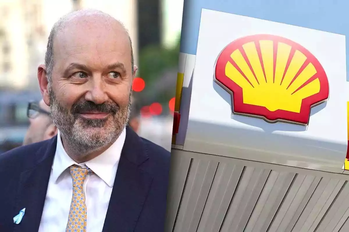 El ministro de desregulación Sturzenegger con barba y traje sonríe mientras está al aire libre junto a una imagen del logotipo de Shell.