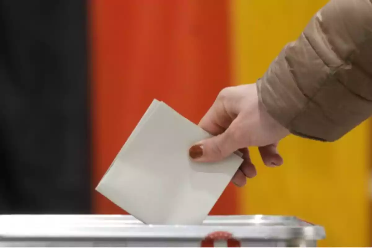 Person casting a vote in a ballot box during an election.