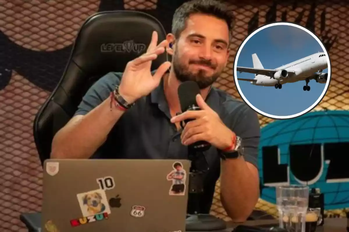 Un hombre con barba está sentado frente a un micrófono y una computadora portátil con pegatinas mientras hace un gesto con la mano y hay una imagen de un avión en la esquina superior derecha.