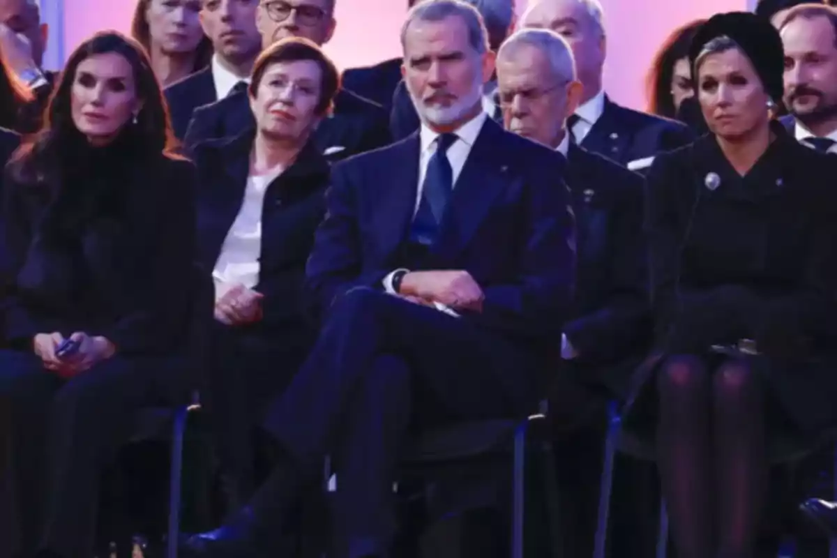 Un grupo de personas vestidas formalmente sentadas en un evento.