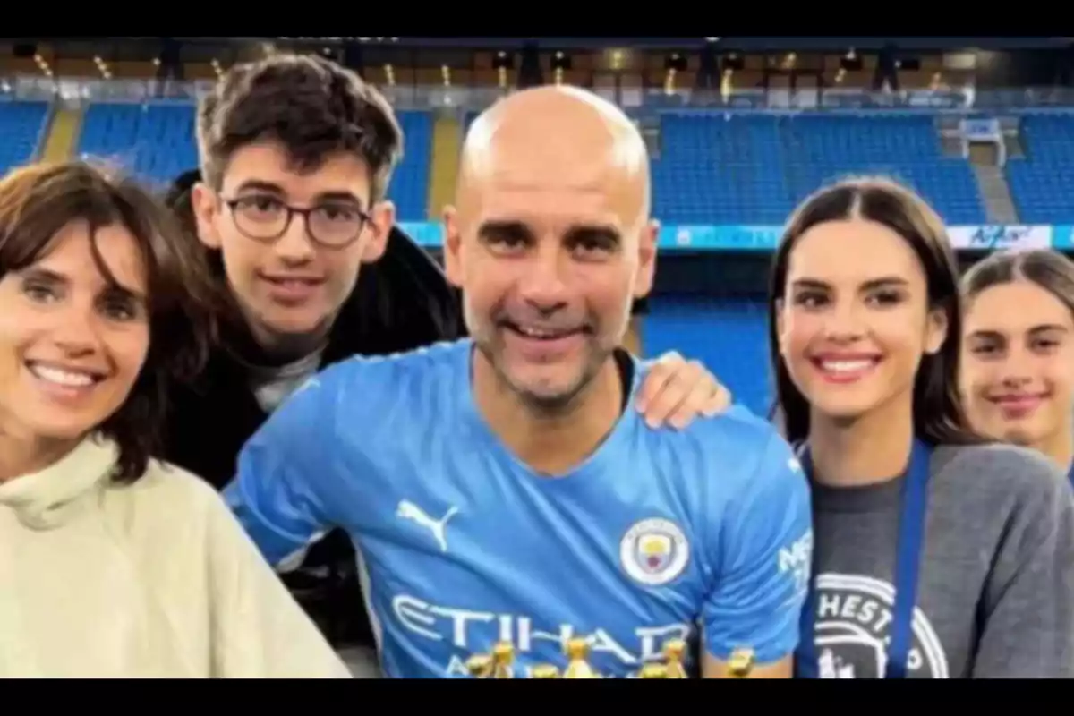 Un grupo de personas sonríe en un estadio de fútbol.