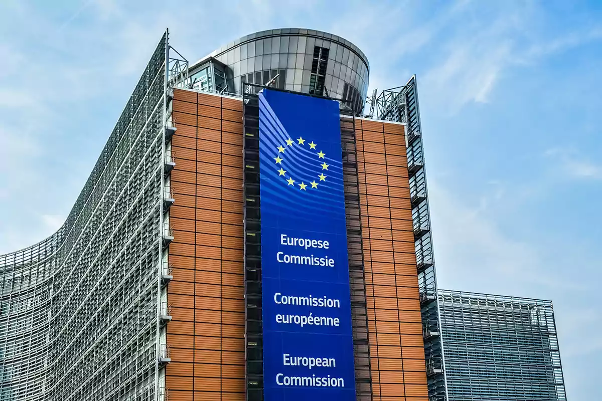 Edificio de la Comisión Europea con un gran cartel azul y el logo de la Unión Europea.