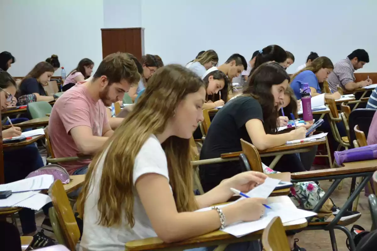 Estudiantes concentrados tomando un examen en un aula.