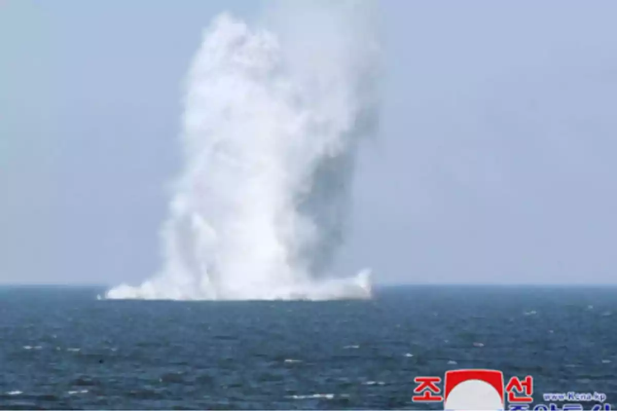 Una gran columna de agua se eleva desde el mar bajo un cielo despejado.