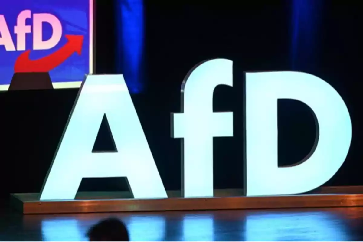 Letras iluminadas "AfD" en un escenario oscuro con un fondo azul.